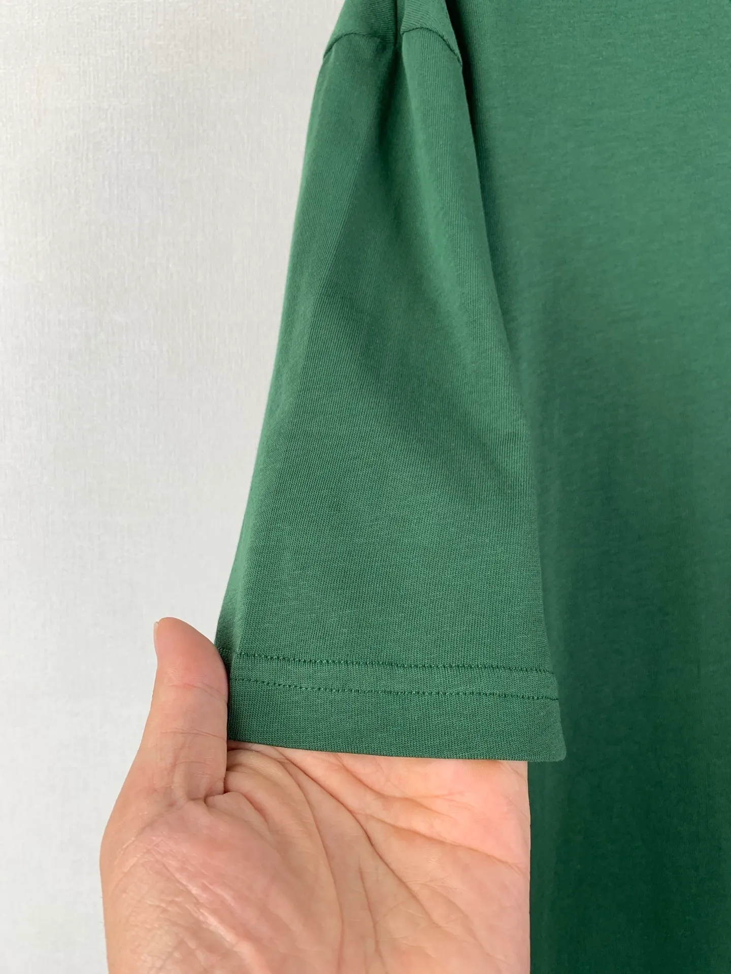 Lacoste crocodile logo short-sleeved T-shirt. Customized combed smooth plain cotton. Smooth and soft. Comfortable. Breathable. The pine dark green that has been deposited by time. The soft tones make people calm and calm. The iconic small crocodile pops up in the heart. The vivid logo contrasts with the calm background. The calm colors show the French style. Cut out the complexity and simplify it. Use solid color as the base and the logo as the print to show the texture and brand heritage in a low-key manner. Process 1: Use the car seal process. Make independent embroidered chapters through computer embroidery, then position them and sew them to fix them on the clothes. They have a strong three-dimensional effect, are strong and washable, and have stable quality. Process 2: The fabrics have been fermented and washed. They have a better hand feel and are not easy to deform, not easy to shrink, not easy to fade, and maintain long-term beauty. Accessories: Customized 1:1 Lacoste crocodile logo Customized 1:1 Lacoste trademark Version: Loose version Size: S M L XL
